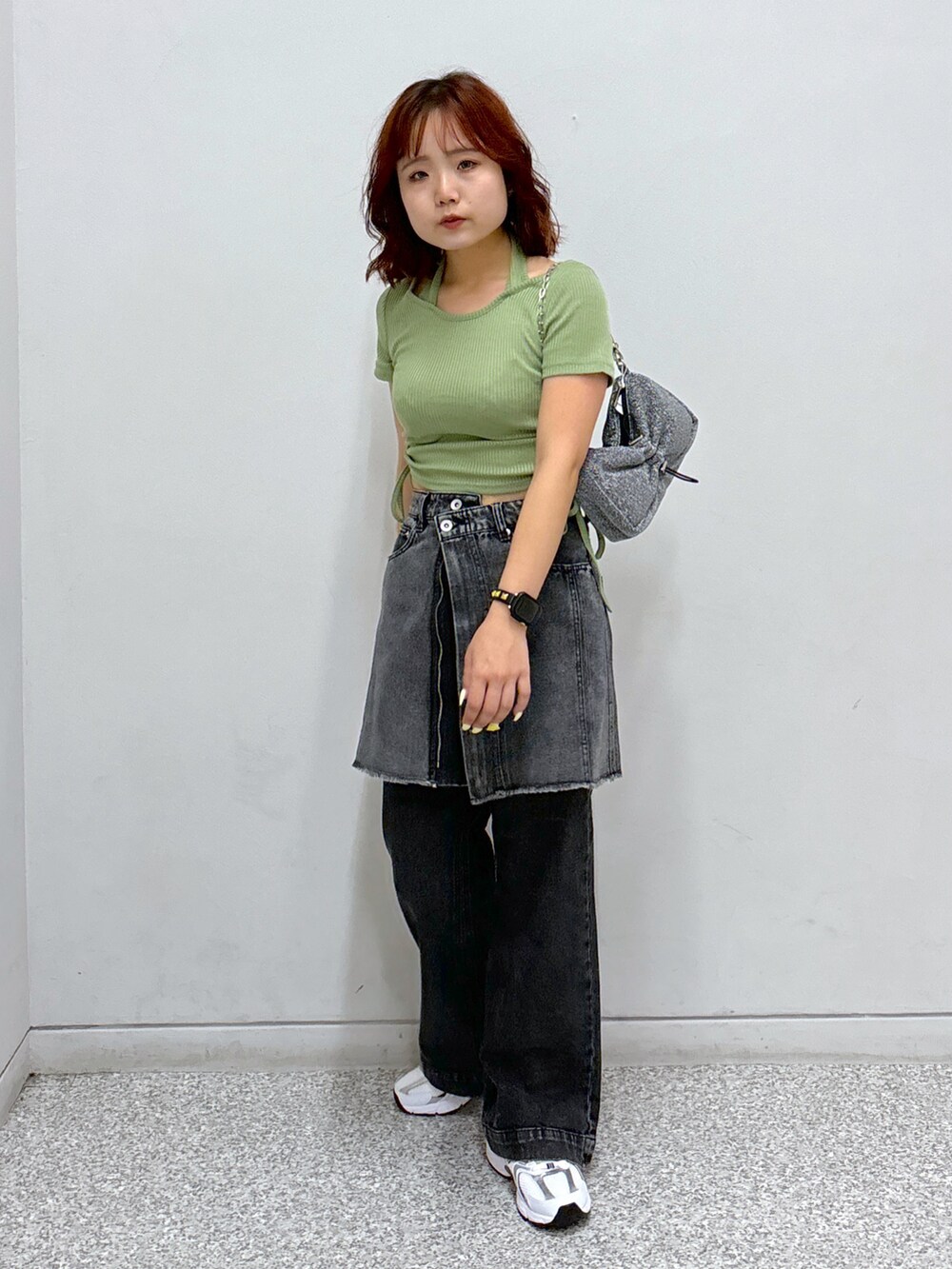 グリーン系のTシャツ/カットソー、ブラック系のスカート、ブラック系のデニムパンツを着用したレディースの秋コーディネートの2枚目の写真