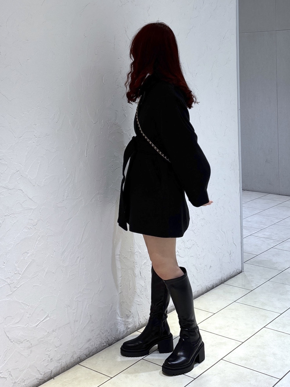 ブラック系のステンカラーコート、ブラック系のその他パンツ、ブラック系のショルダーバッグを着用したレディースの秋コーディネートの5枚目の写真