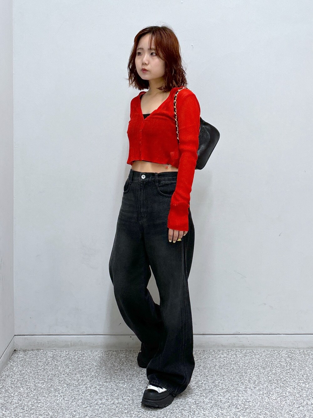 レッド系のカーディガン/ボレロ、ブラック系のトートバッグ、ブラック系のキャミソールを着用したレディースの秋コーディネートの2枚目の写真