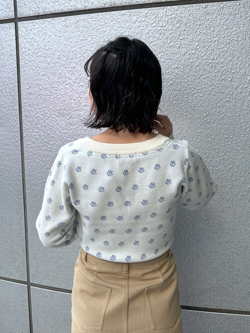 ブラック系のショルダーバッグ、ベージュ系のスカート、ホワイト系のニット/セーターを着用したレディースの冬コーディネートの4枚目の写真