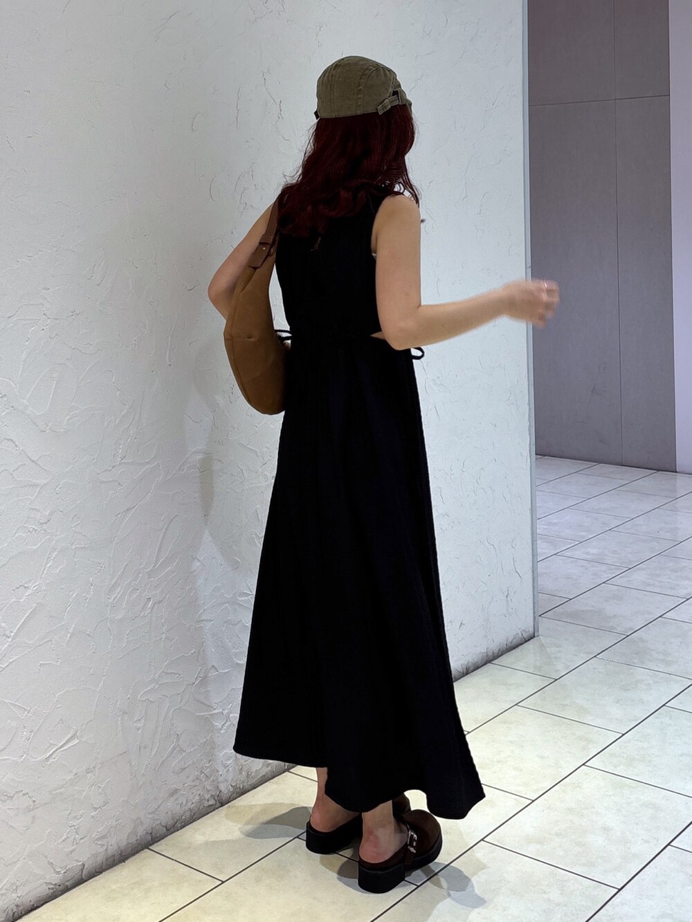 ブラック系のワンピース、ブラウン系のハンドバッグ、ホワイト系のキャミソールを着用したレディースの夏コーディネートの7枚目の写真