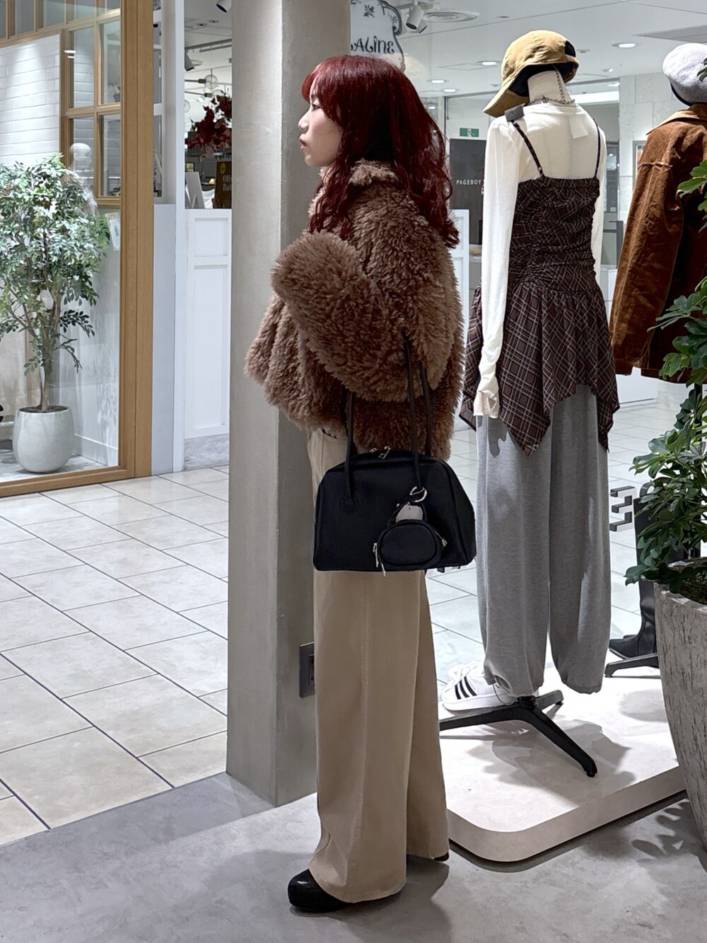 ブラウン系のブルゾン、ベージュ系のデニムパンツ、ブラック系のトートバッグを着用したレディースの秋コーディネートの6枚目の写真