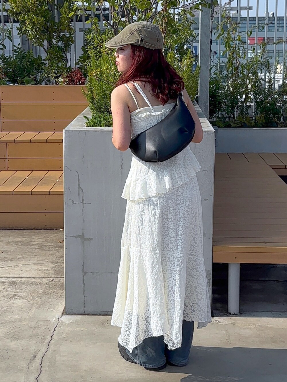 ホワイト系のワンピース、ブルー系のデニムパンツ、ホワイト系のスニーカーを着用したレディースの夏コーディネートの7枚目の写真