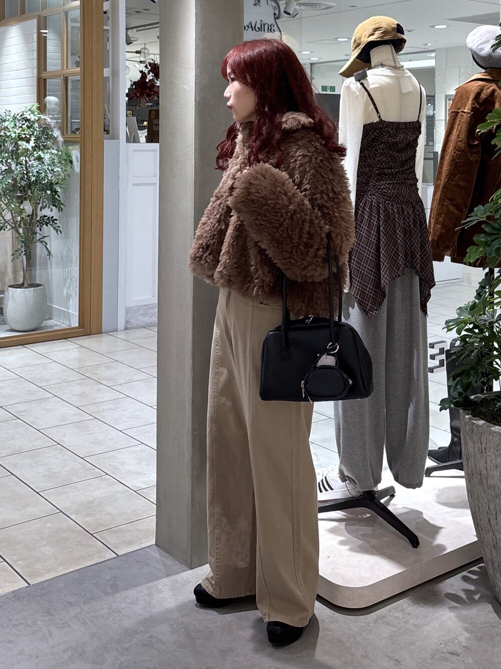 ブラウン系のブルゾン、ベージュ系のデニムパンツ、ブラック系のトートバッグを着用したレディースの秋コーディネートの5枚目の写真