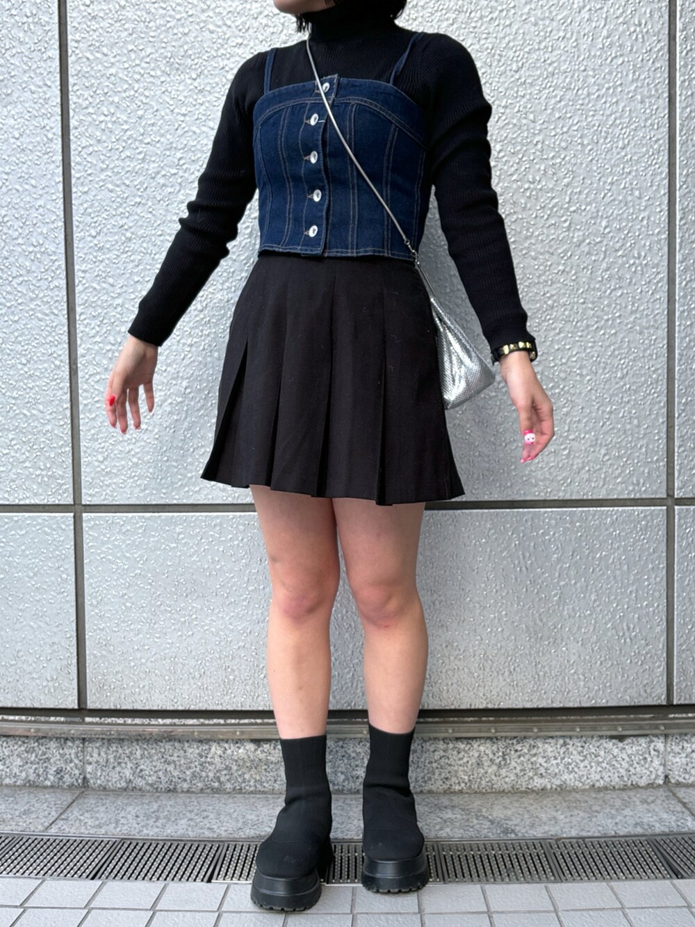 ブルー系のベスト、ブラック系のスカート、ブラック系のニット/セーターを着用したレディースの冬コーディネートの5枚目の写真