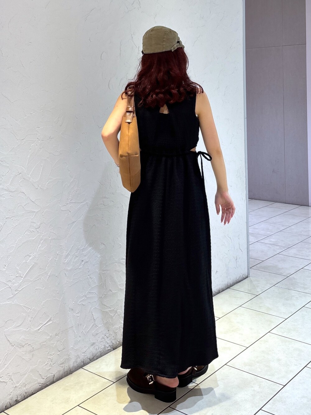 ブラック系のワンピース、ブラウン系のハンドバッグ、ホワイト系のキャミソールを着用したレディースの夏コーディネートの6枚目の写真