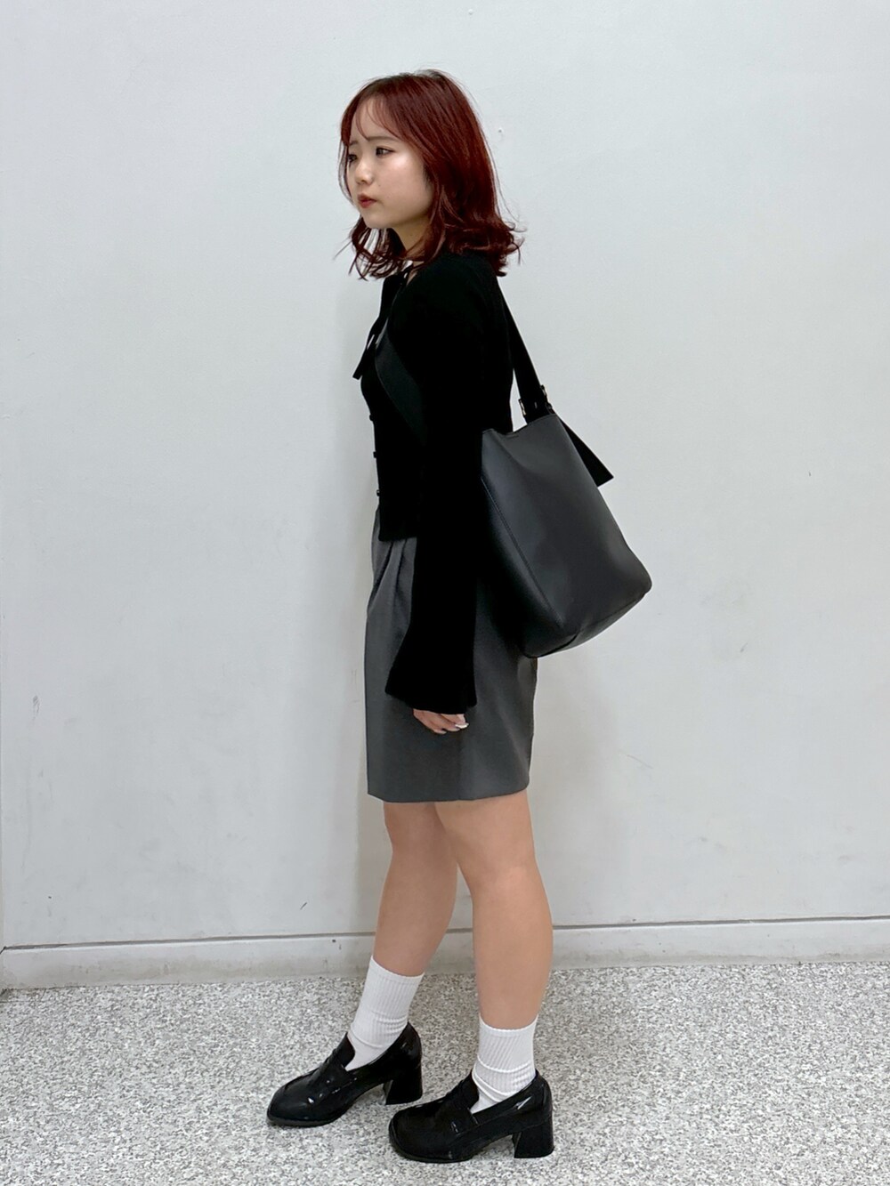 ブラック系のニット/セーター、グレー系のその他パンツ、ブラック系のローファーを着用したレディースの秋コーディネートの3枚目の写真