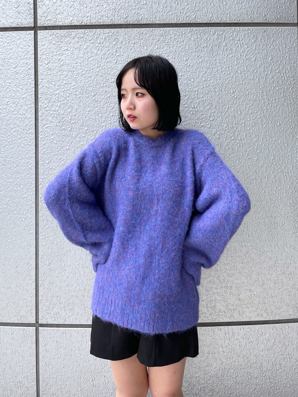 ブルー系のニット/セーター、ブラック系のその他パンツ、ブラック系のブーツを着用したレディースの秋コーディネートの4枚目の写真