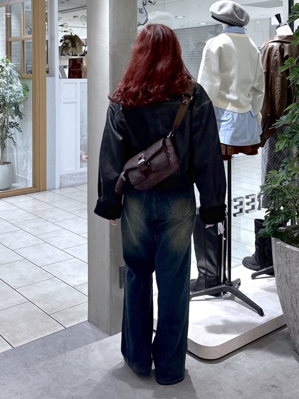 ブラック系のブルゾン、ブルー系のデニムパンツ、ブラウン系のショルダーバッグを着用したレディースの秋コーディネートの6枚目の写真