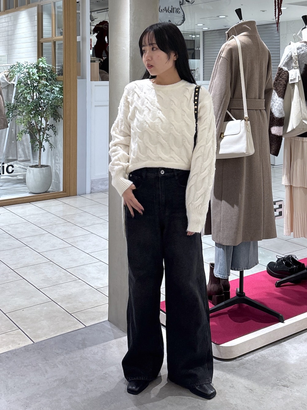 ホワイト系のニット/セーター、ブラック系のデニムパンツ、ブラック系のブーツを着用したレディースの冬コーディネートの3枚目の写真