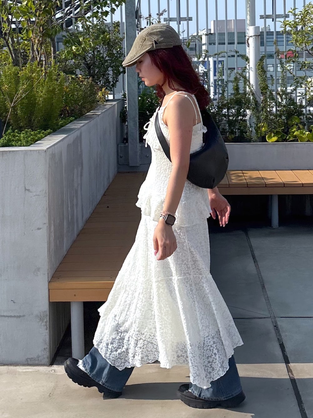 ホワイト系のワンピース、ブルー系のデニムパンツ、ホワイト系のスニーカーを着用したレディースの夏コーディネートの4枚目の写真