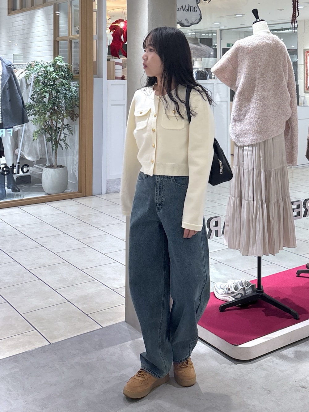 ホワイト系のニット/セーター、ベージュ系のスニーカー、ブラック系のハンドバッグを着用したレディースの冬コーディネートの4枚目の写真