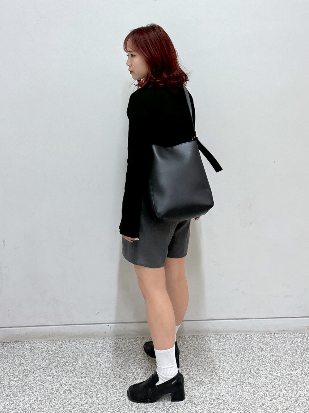 ブラック系のニット/セーター、グレー系のその他パンツ、ブラック系のローファーを着用したレディースの秋コーディネートの4枚目の写真