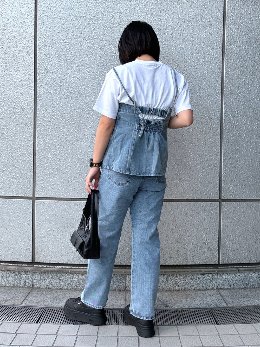 ブルー系のデニムパンツ、ブルー系のベスト、ホワイト系のTシャツ/カットソーを着用したレディースの春コーディネートの3枚目の写真