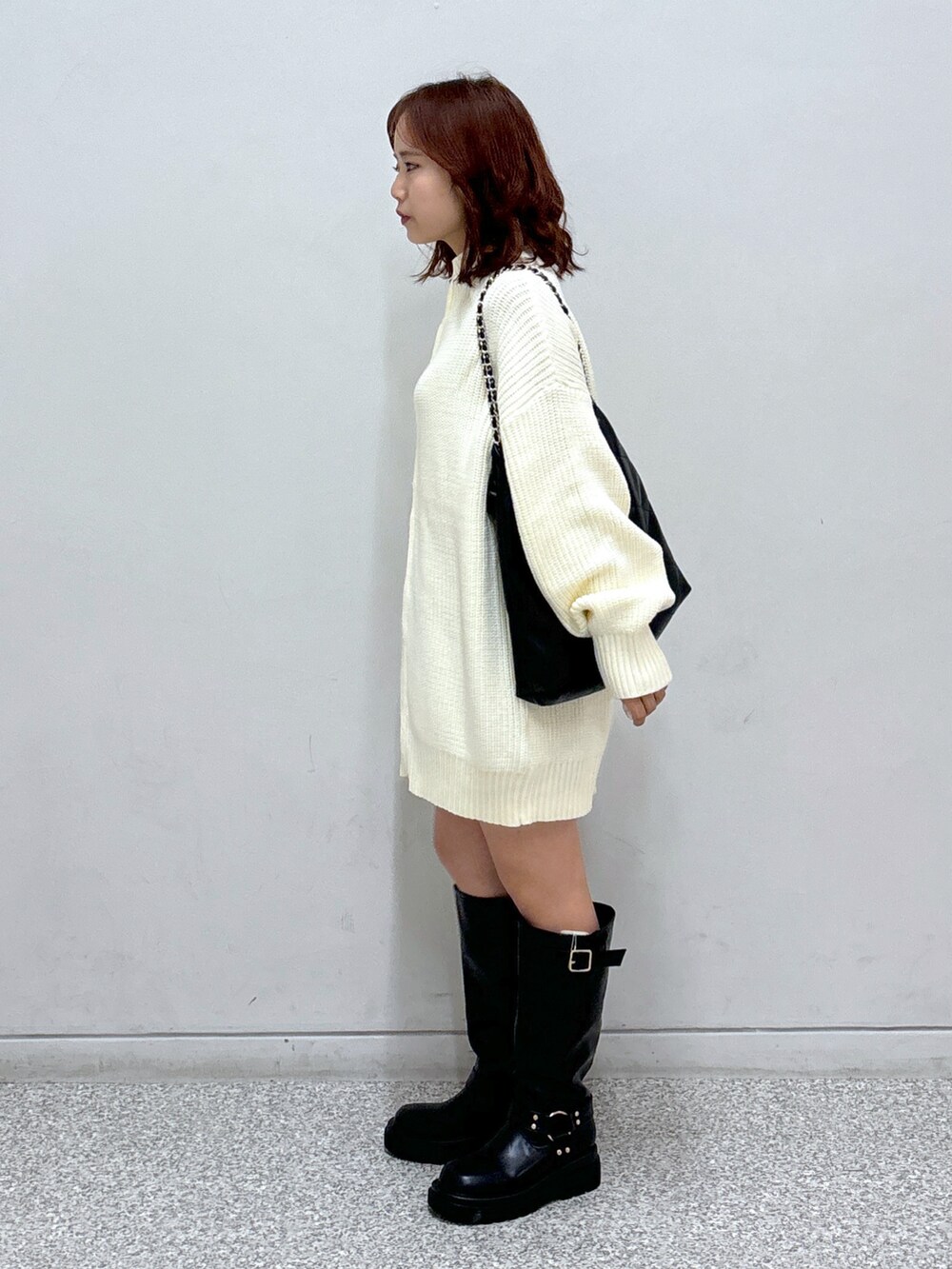 ホワイト系のワンピース、グレー系のスカート、ブラック系のトートバッグを着用したレディースの秋コーディネートの3枚目の写真