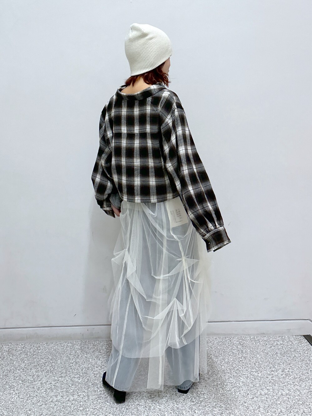 ブラウン系のシャツ/ブラウス、ホワイト系のスカート、ブルー系のデニムパンツを着用したレディースの秋コーディネートの4枚目の写真