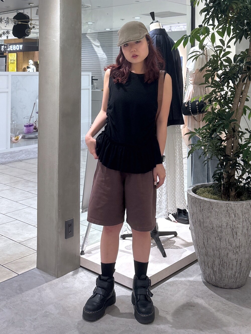 ブラウン系のデニムパンツ、ブラック系のブーツ、ブラック系のTシャツ/カットソーを着用したレディースの夏コーディネートの2枚目の写真