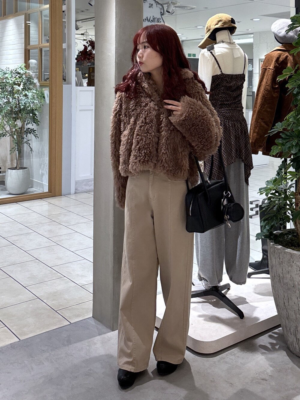 ブラウン系のブルゾン、ベージュ系のデニムパンツ、ブラック系のトートバッグを着用したレディースの秋コーディネートの4枚目の写真