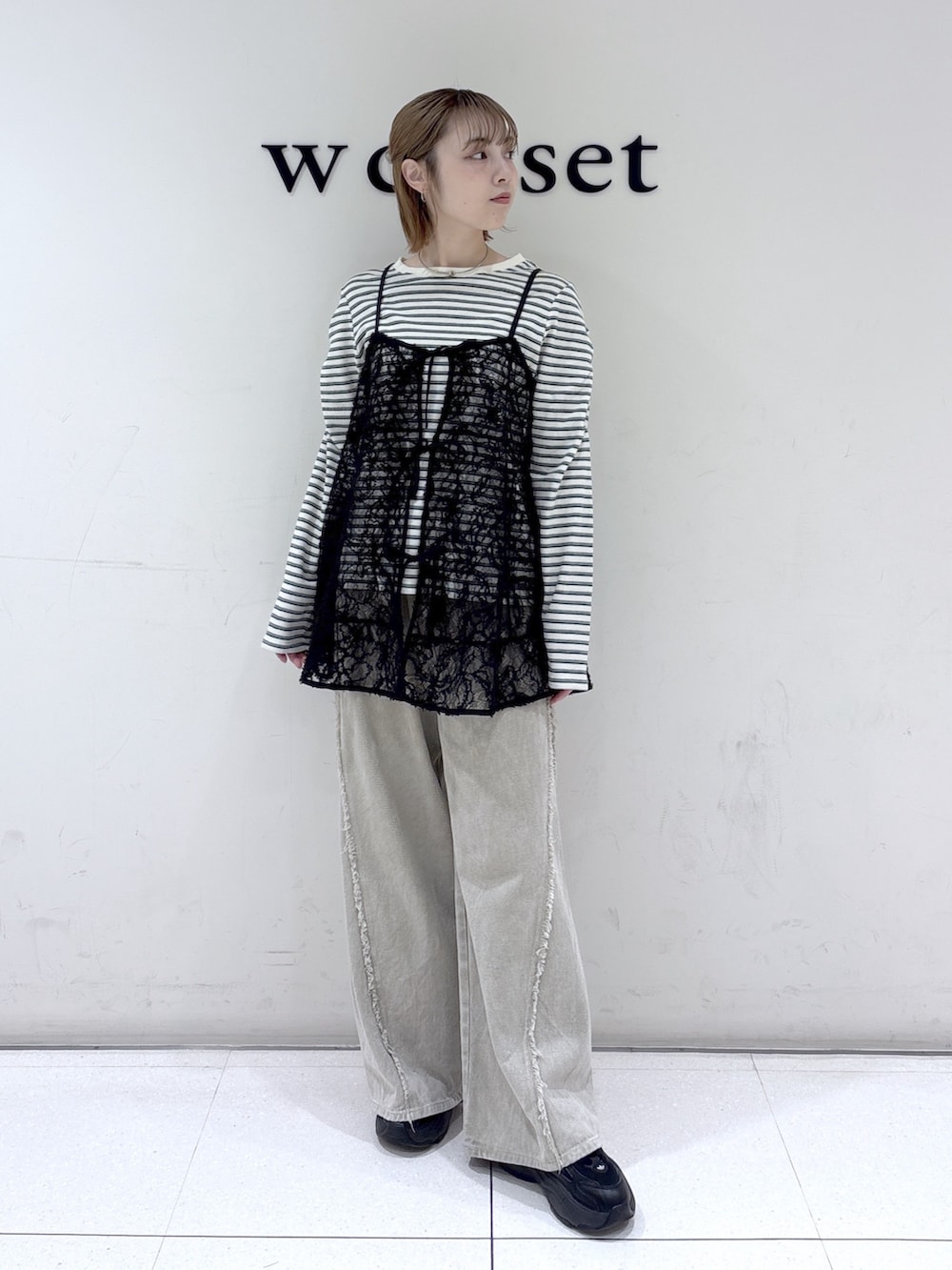 ブラック系のワンピース、ベージュ系のデニムパンツ、ブラック系のTシャツ/カットソーを着用したレディースの春コーディネートの2枚目の写真