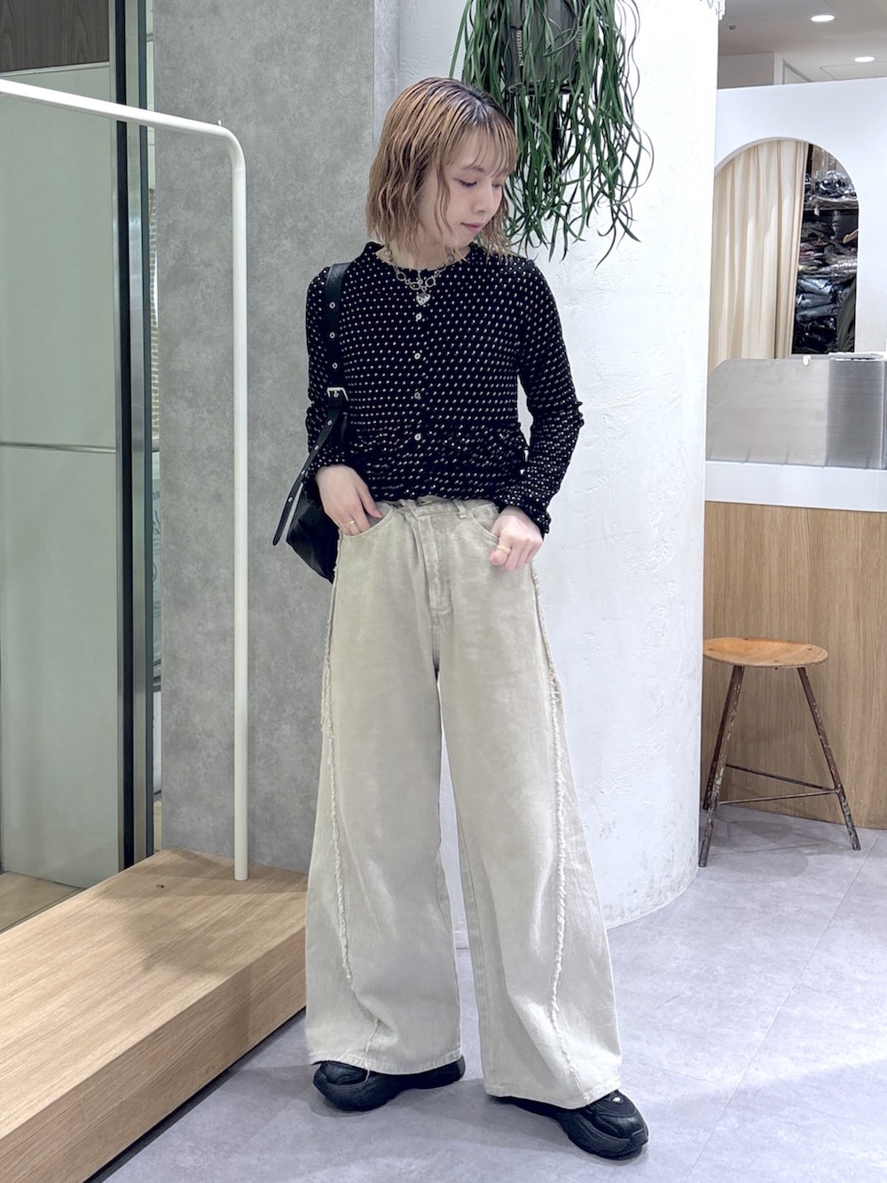 ベージュ系のデニムパンツ、ブラック系のTシャツ/カットソー、ブラック系のトートバッグを着用したレディースの春コーディネートの2枚目の写真