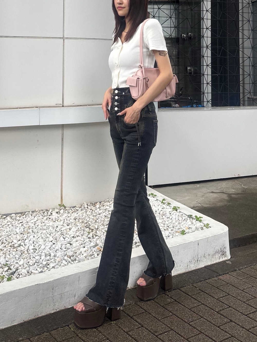 ブルー系のデニムパンツ、ブラウン系のサンダル、ピンク系のハンドバッグを着用したレディースの夏コーディネートの2枚目の写真