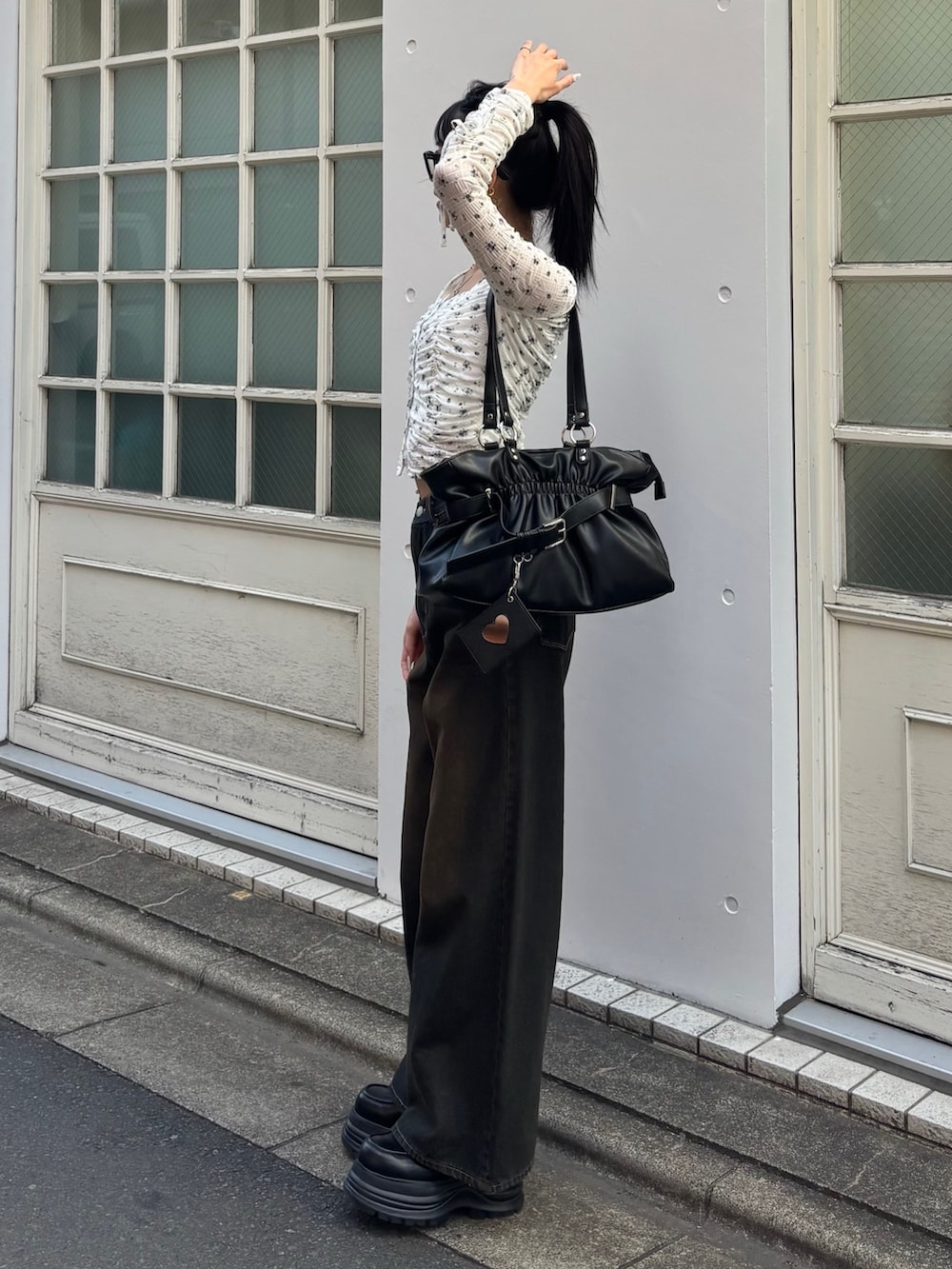 ブルー系のデニムパンツ、ブラック系のローファー、ブラック系のトートバッグを着用したレディースの冬コーディネートの2枚目の写真