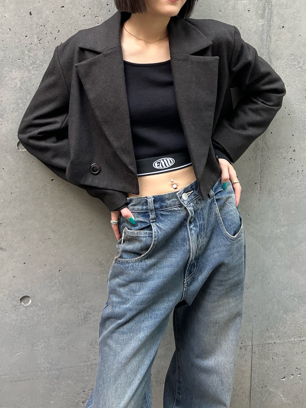 ブルー系のデニムパンツ、ブラック系のブーツ、ブラック系のハンドバッグを着用したレディースの夏コーディネートの3枚目の写真