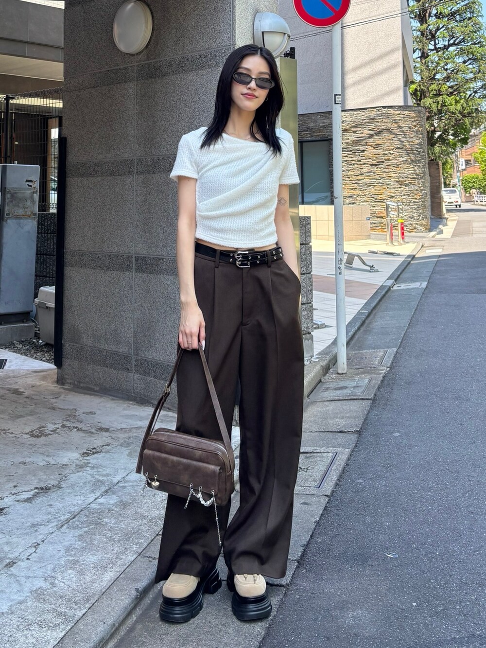 ブラウン系のハンドバッグ、ベージュ系のローファー、ホワイト系のTシャツ/カットソーを着用したレディースの夏コーディネートの2枚目の写真