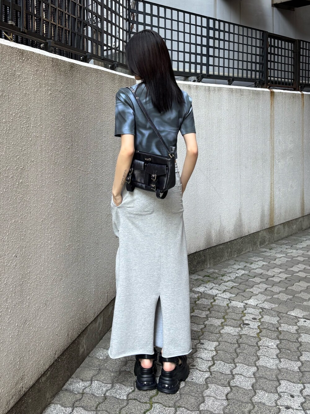 ブルー系のTシャツ/カットソー、グレー系のスカート、ブラック系のサンダルを着用したレディースの春コーディネートの2枚目の写真