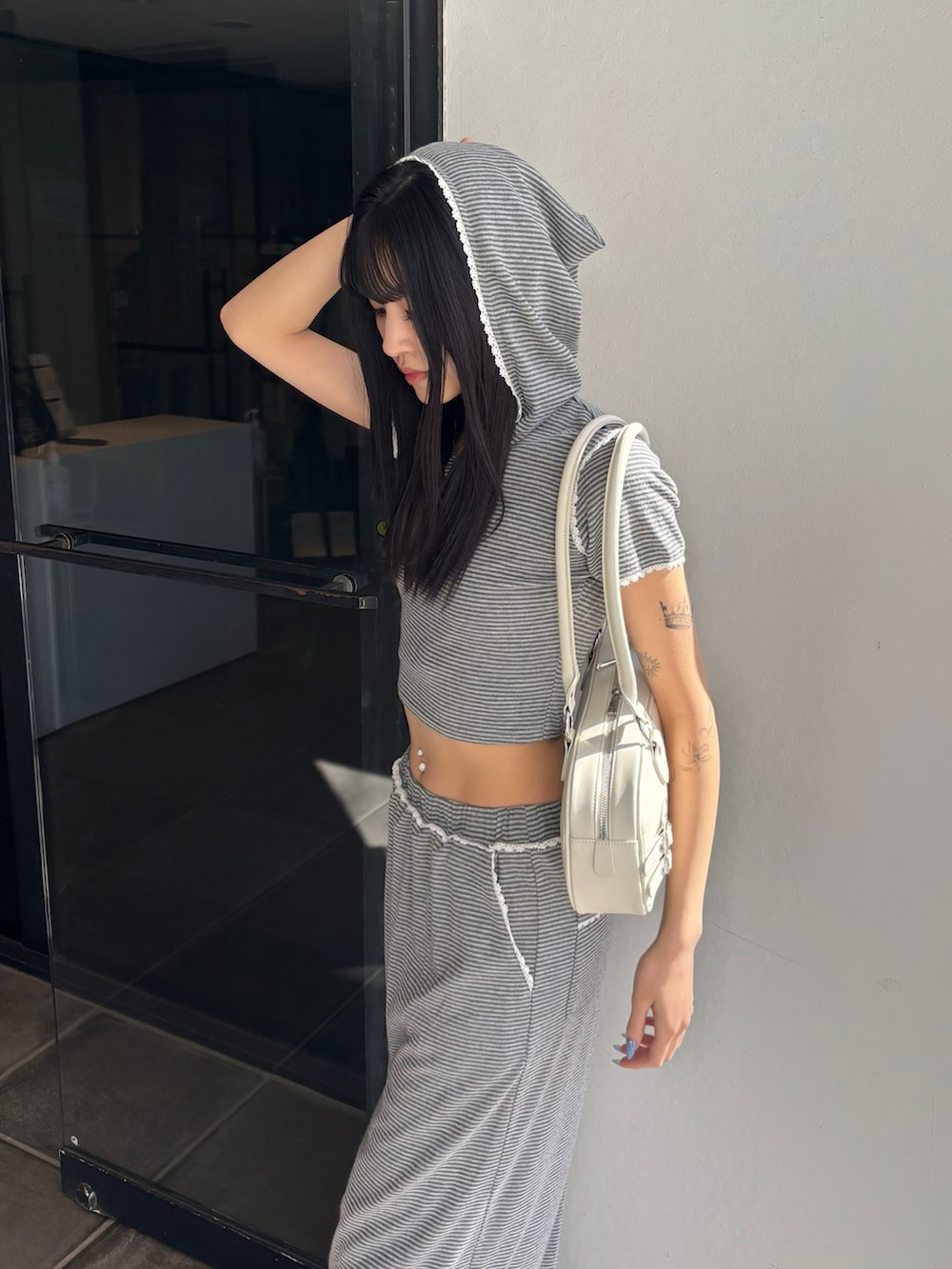 グレー系のTシャツ/カットソー、グレー系のスカート、ホワイト系のブーツを着用したレディースの冬コーディネートの3枚目の写真