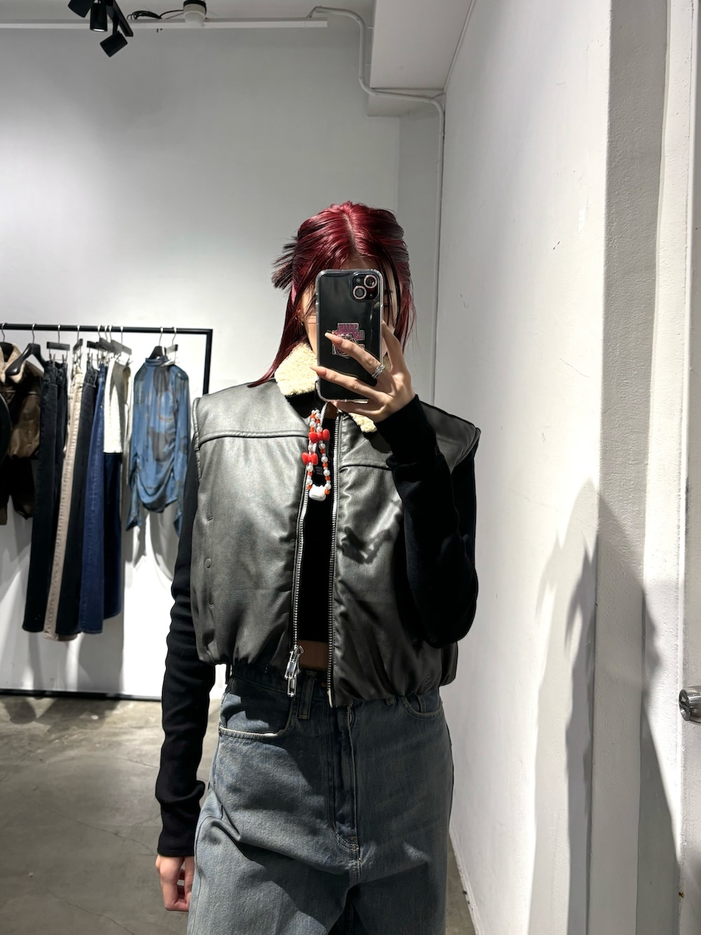 グレー系のベスト、ブルー系のデニムパンツを着用したレディースの秋コーディネートの2枚目の写真