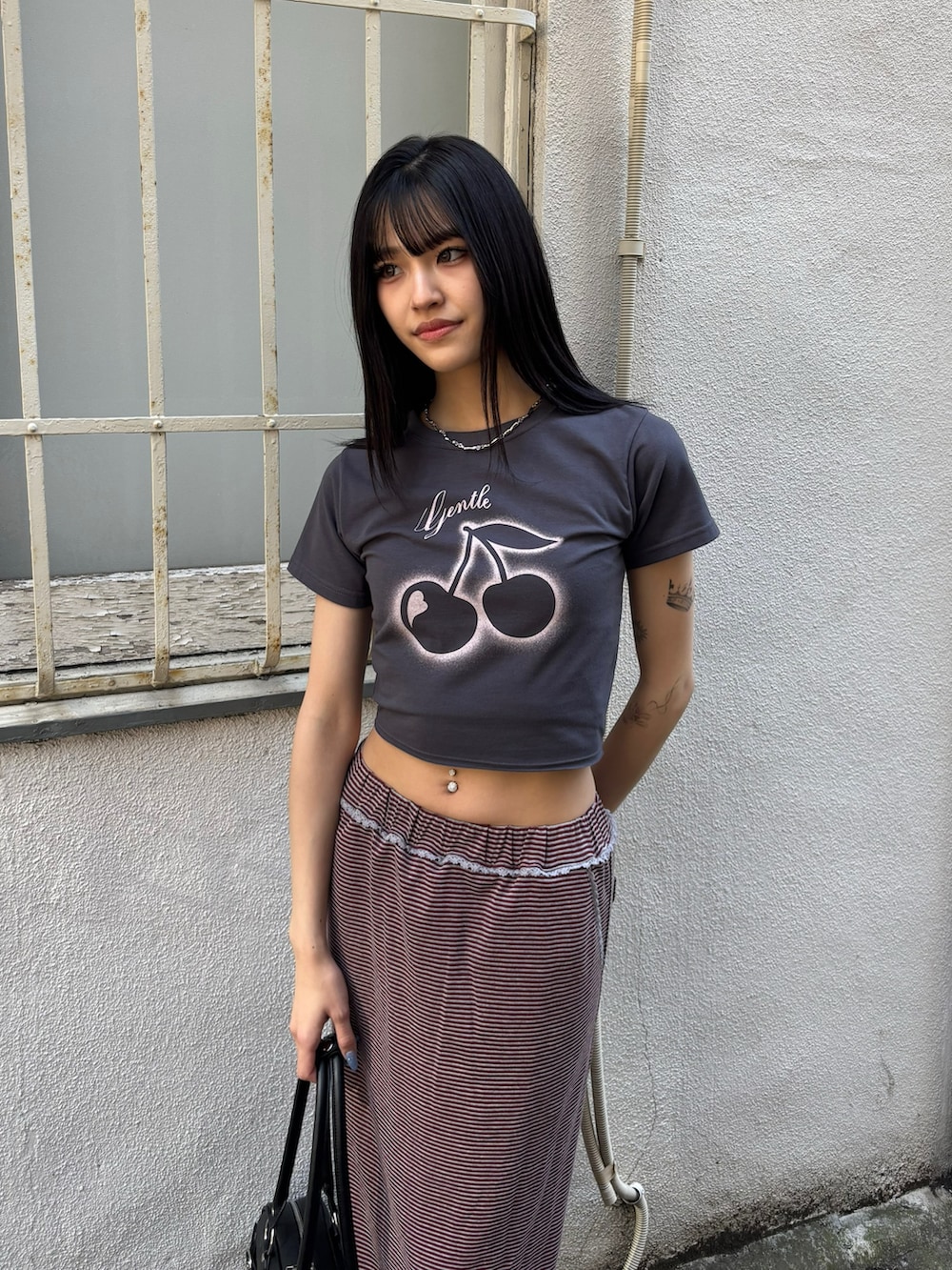 レッド系のスカート、ブラック系のブーツ、グレー系のTシャツ/カットソーを着用したレディースの冬コーディネートの2枚目の写真