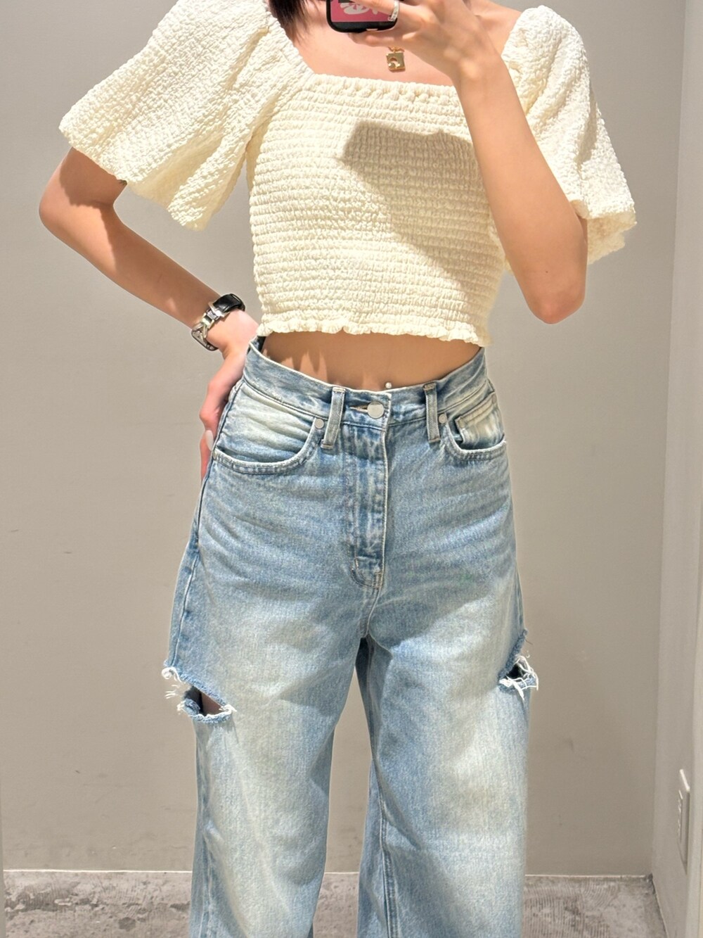 ブルー系のデニムパンツ、ホワイト系のTシャツ/カットソー、ブラック系のサンダルを着用したレディースの夏コーディネートの3枚目の写真