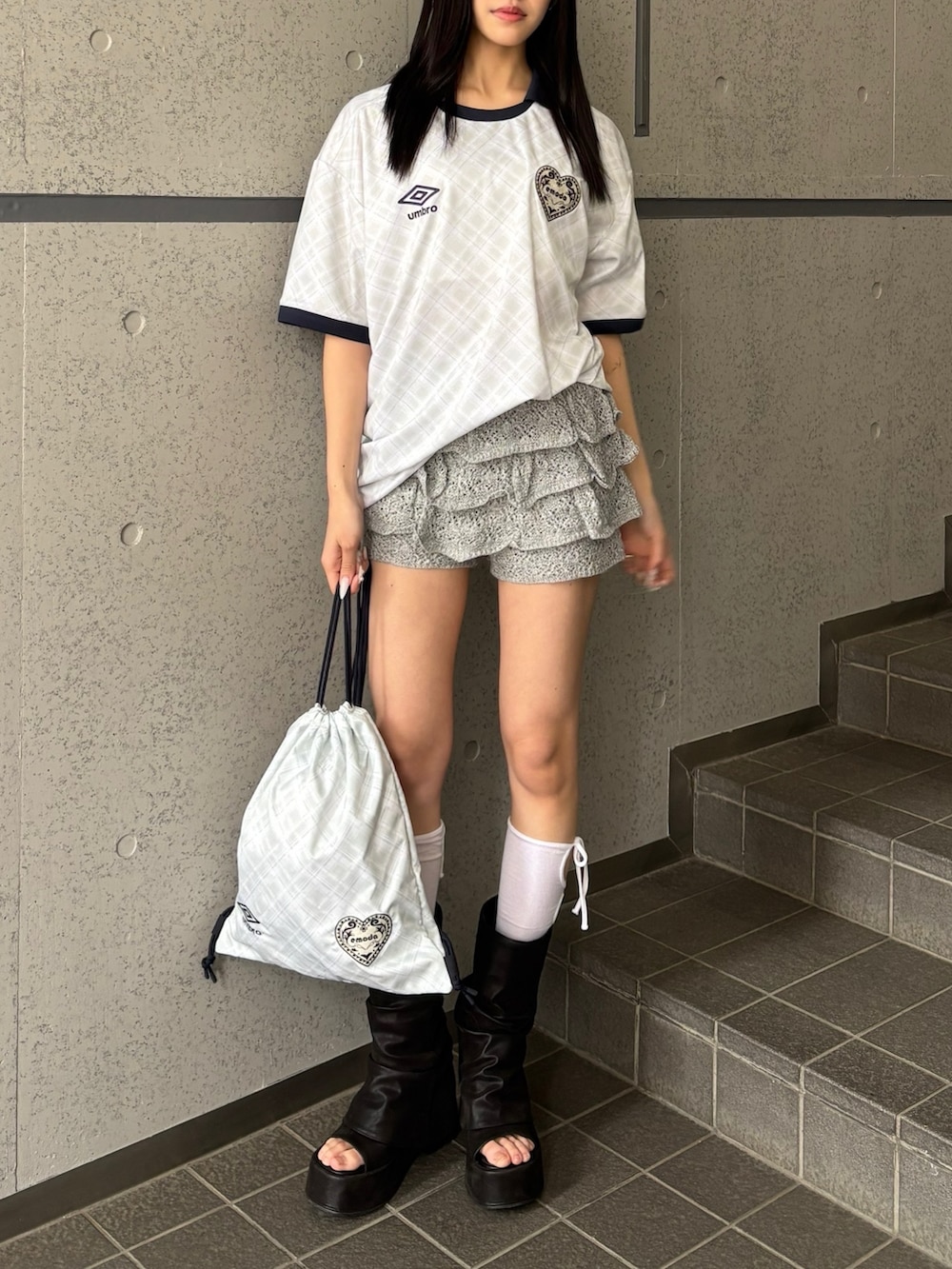 グレー系のスカート、ホワイト系のTシャツ/カットソー、ホワイト系のバックパック/リュックを着用したレディースの冬コーディネートの2枚目の写真