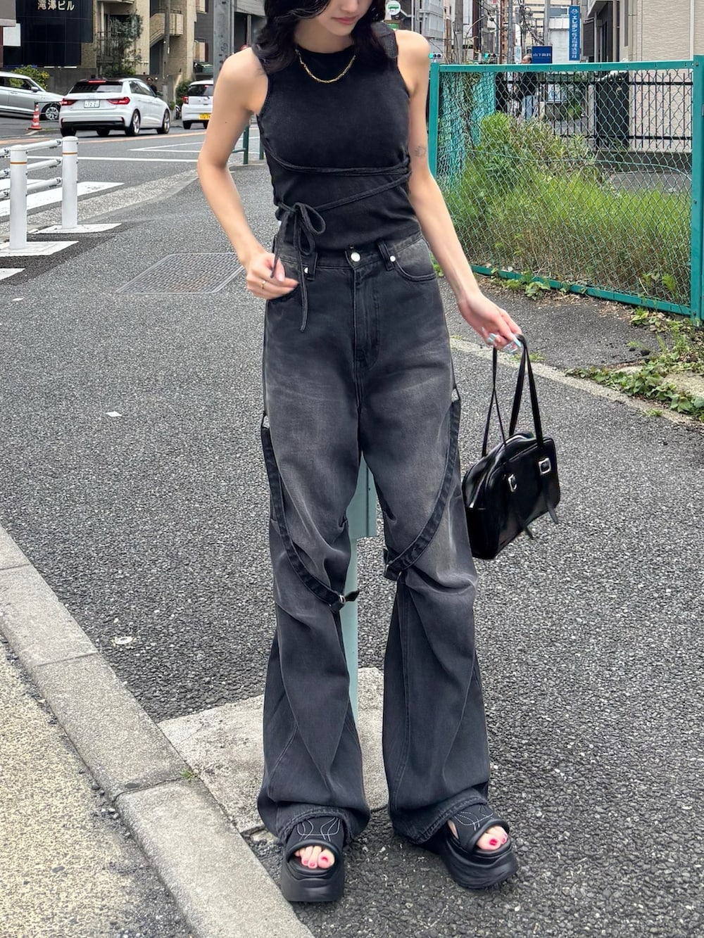 ブラック系のTシャツ/カットソー、ブラック系のデニムパンツ、ブラック系のサンダルを着用したレディースの夏コーディネートの2枚目の写真