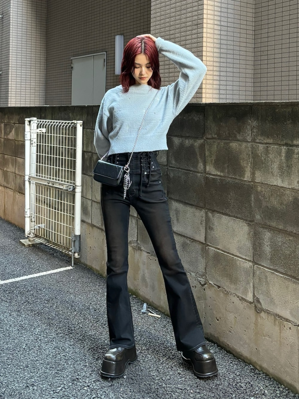 ブラック系のデニムパンツ、ブラック系のローファー、グレー系のニット/セーターを着用したレディースの秋コーディネートの2枚目の写真