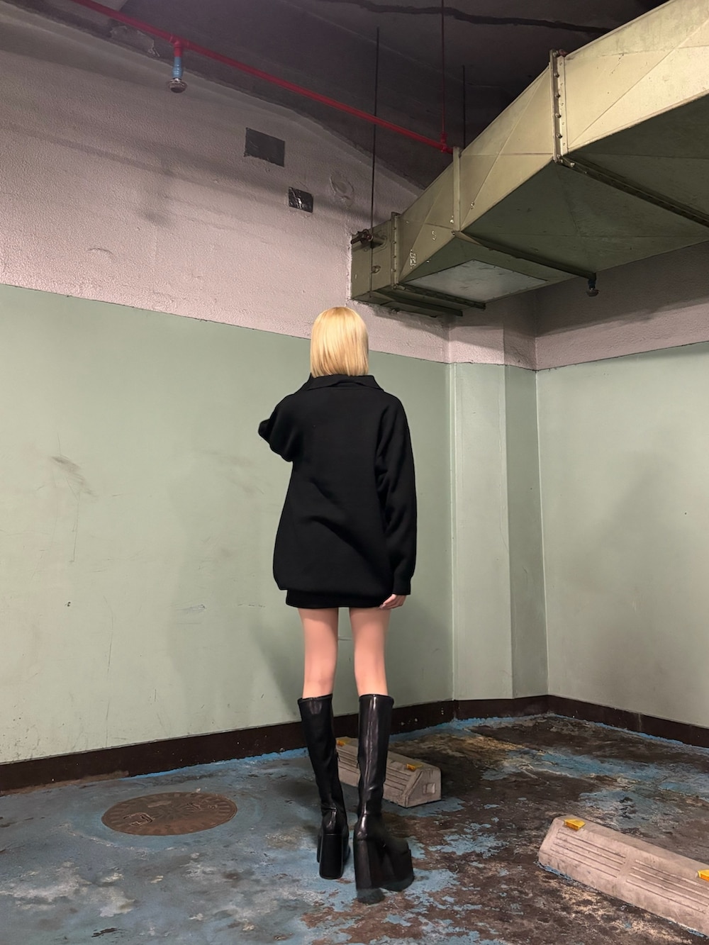 ブラック系のワンピース、ブラック系のブーツ、ブラック系のスカートを着用したレディースの秋コーディネートの2枚目の写真