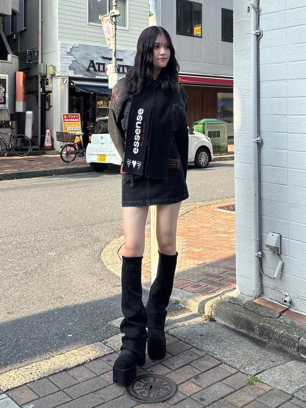 ブラック系のスカート、ブラック系のブルゾン、ブラック系のブーツを着用したレディースの秋コーディネートの2枚目の写真