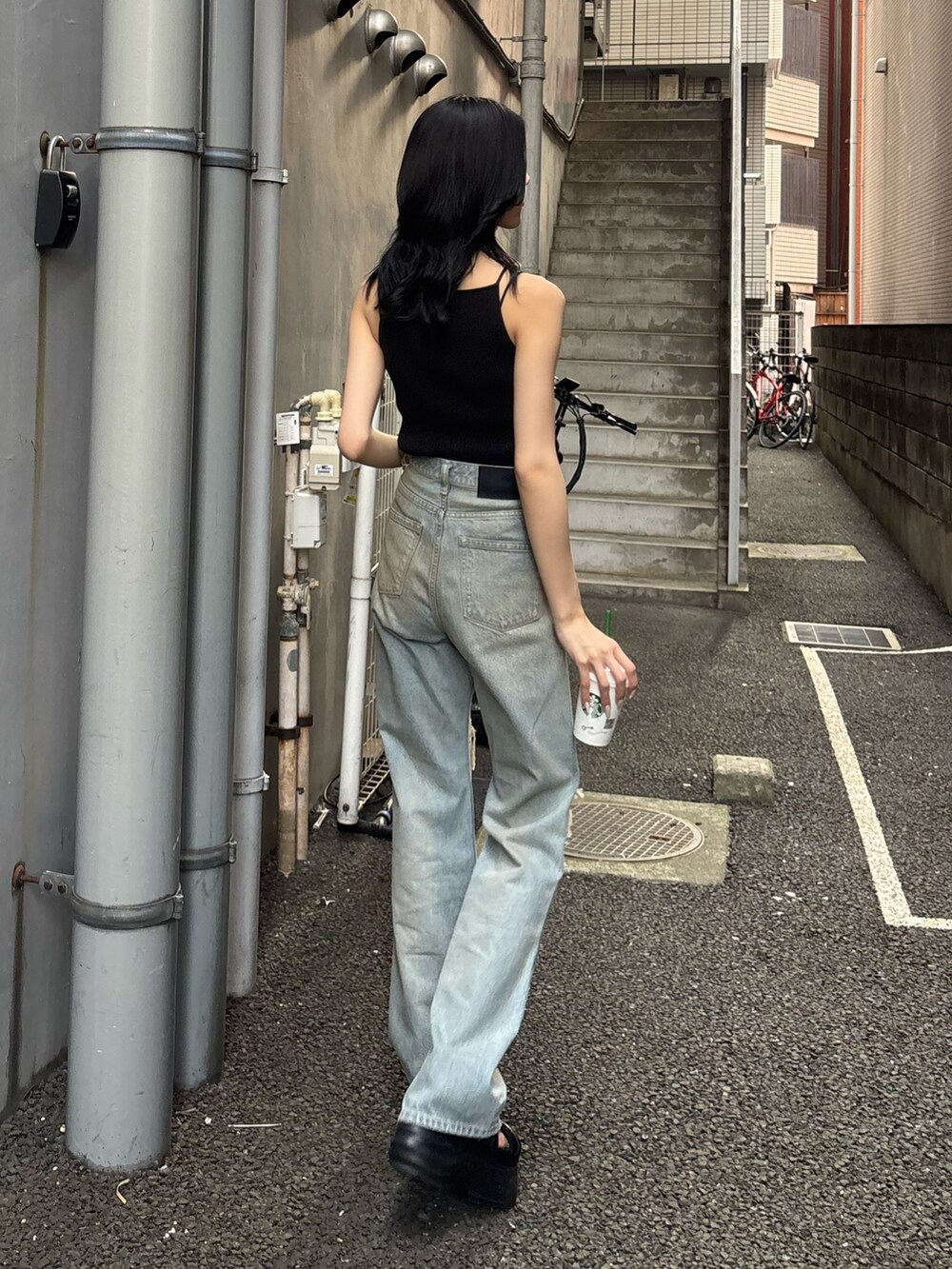 ブルー系のデニムパンツ、ブラック系のキャミソール、ブラック系のサンダルを着用したレディースの春コーディネートの2枚目の写真