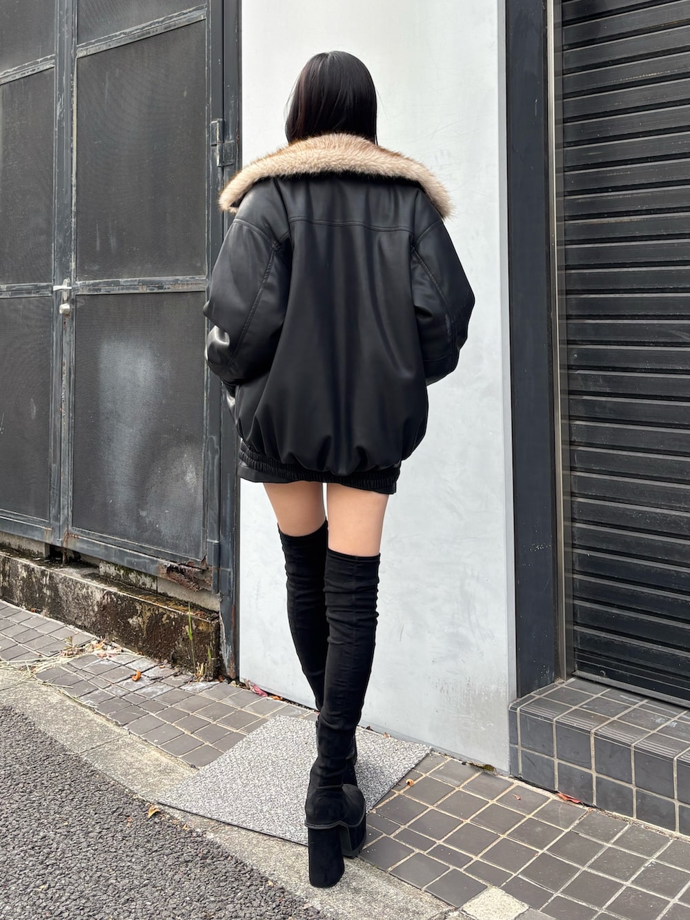 ブラック系のブーツ、ブラック系のニット/セーター、ブラック系のブルゾンを着用したレディースの秋コーディネートの2枚目の写真