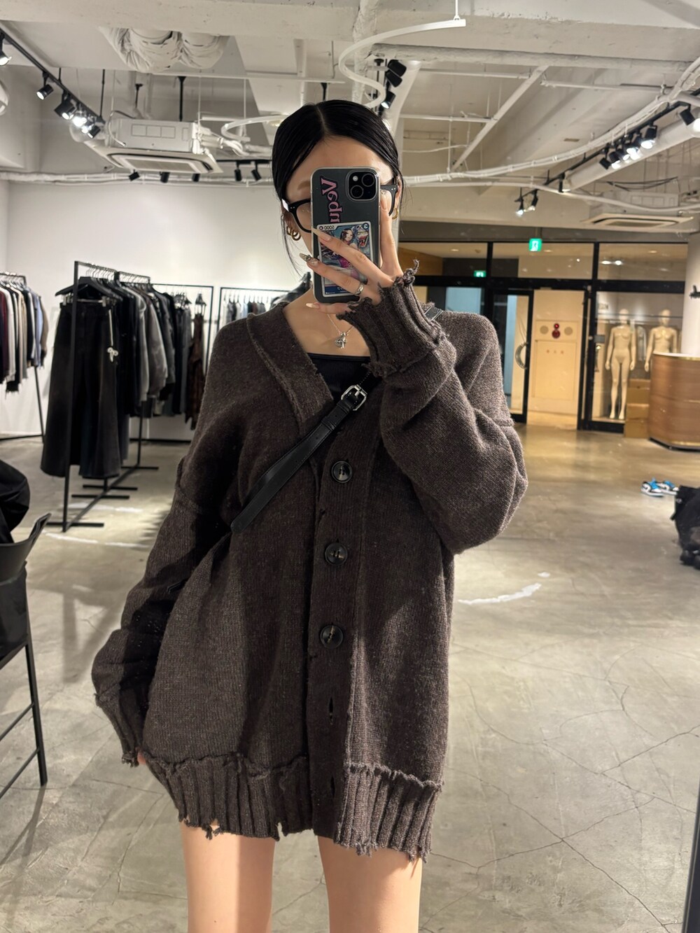 ブラック系のブーツ、ブラック系のハンドバッグ、ブラウン系のカーディガン/ボレロを着用したレディースの秋コーディネートの2枚目の写真