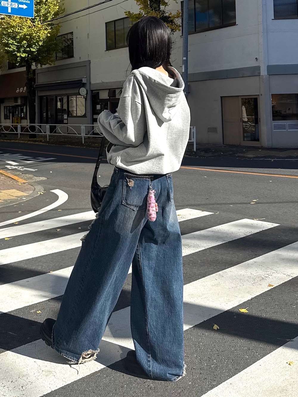 ブルー系のデニムパンツ、ブラック系のブーツ、グレー系のパーカーを着用したレディースの冬コーディネートの2枚目の写真