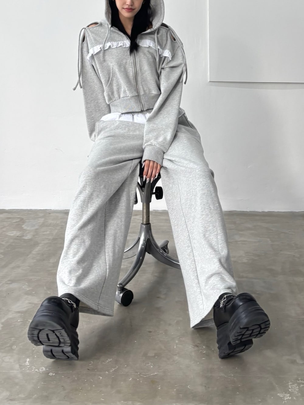 ブラック系のローファー、グレー系のスウェットパンツ、グレー系のパーカーを着用したレディースの冬コーディネートの2枚目の写真