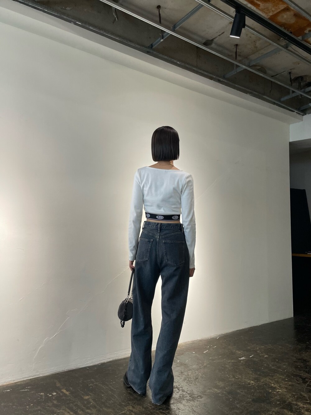 ホワイト系のTシャツ/カットソー、ブルー系のデニムパンツ、グレー系のハンドバッグを着用したレディースの夏コーディネートの2枚目の写真