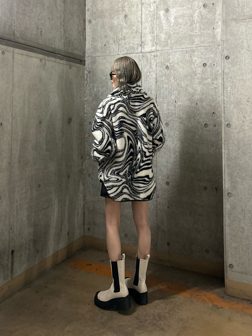 ブラック系のTシャツ/カットソー、ブラック系のその他パンツ、ホワイト系のブーツを着用したレディースの冬コーディネートの2枚目の写真