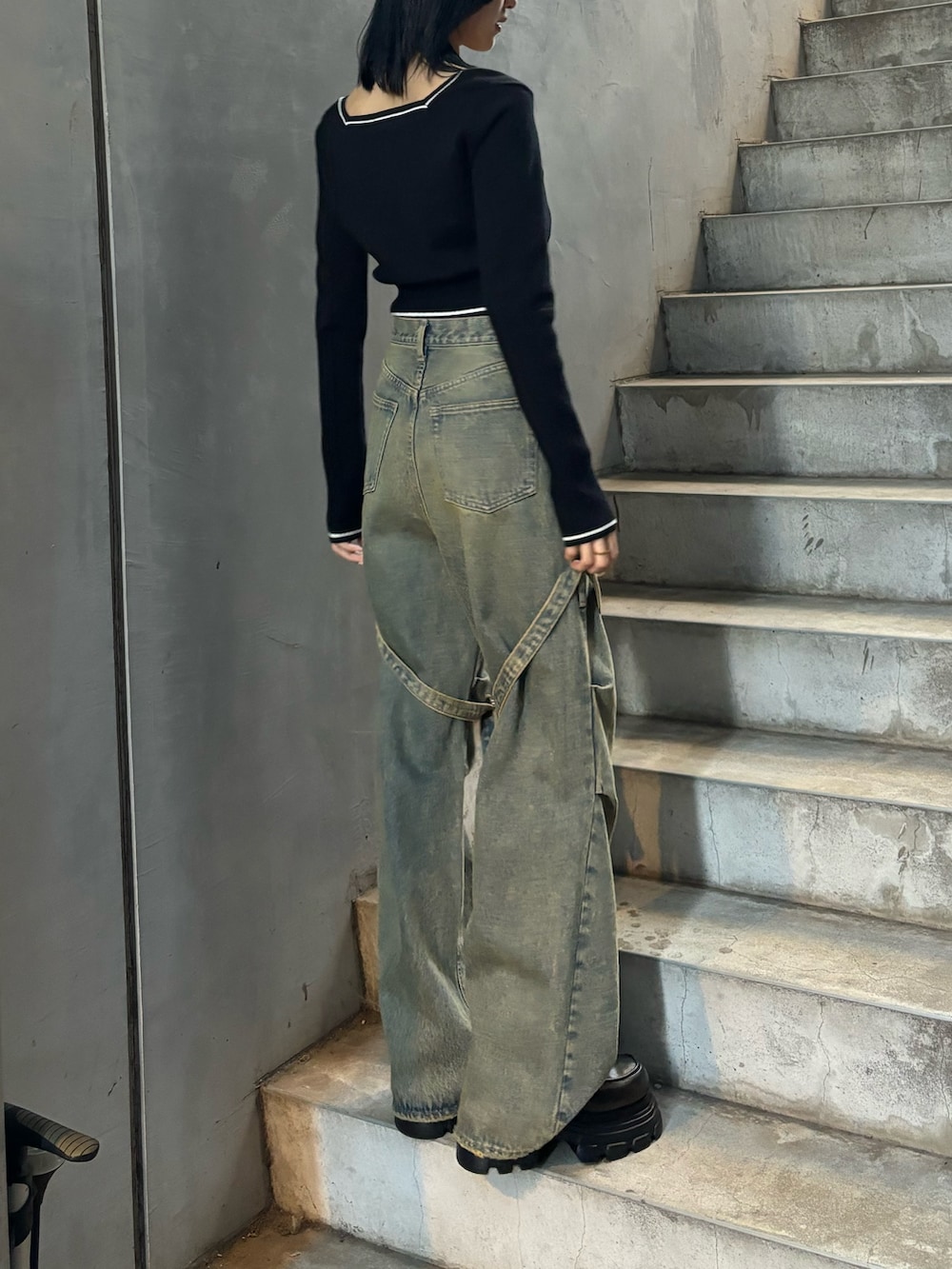 ブラック系のローファー、ブルー系のデニムパンツ、ブラック系のニット/セーターを着用したレディースの冬コーディネートの2枚目の写真