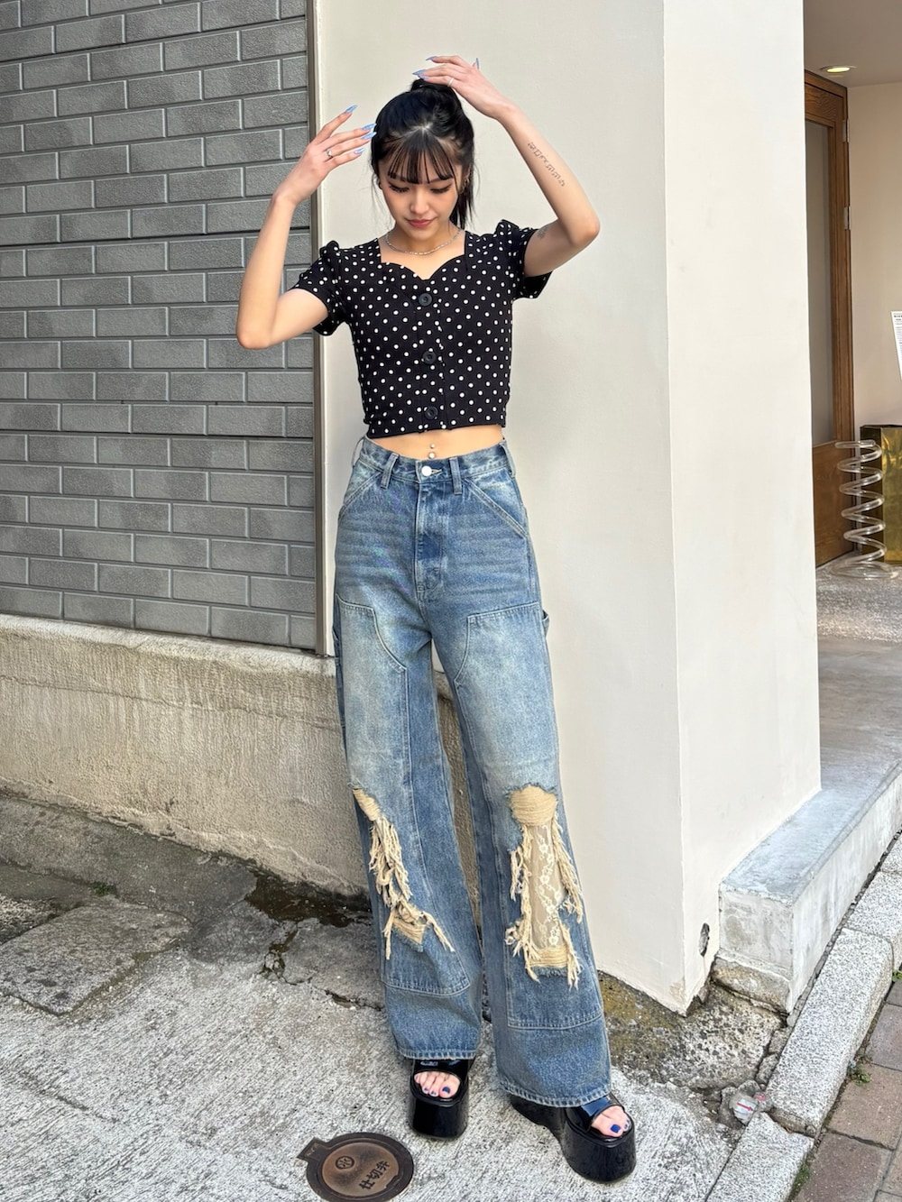 ブルー系のデニムパンツ、ブラック系のサンダルを着用したレディースの春コーディネートの2枚目の写真