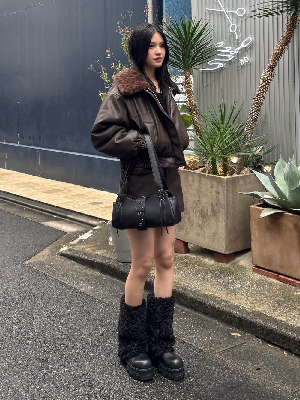 ブラウン系のブルゾン、ブラック系のTシャツ/カットソー、ブラウン系のスカートを着用したレディースの秋コーディネートの2枚目の写真