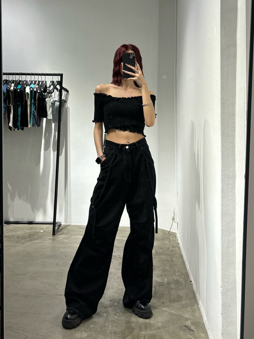 ブラック系のデニムパンツ、ブラック系のブーツ、ブラック系のTシャツ/カットソーを着用したレディースの夏コーディネートの2枚目の写真