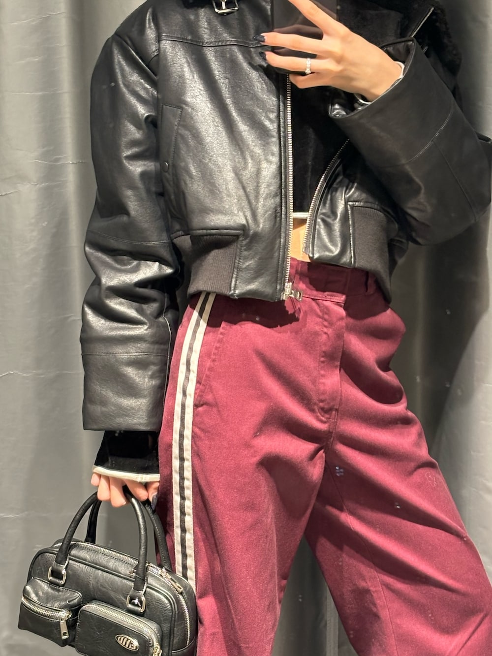 レッド系のその他パンツ、ブラック系のブーツ、ブラック系のブルゾンを着用したレディースの秋コーディネートの2枚目の写真